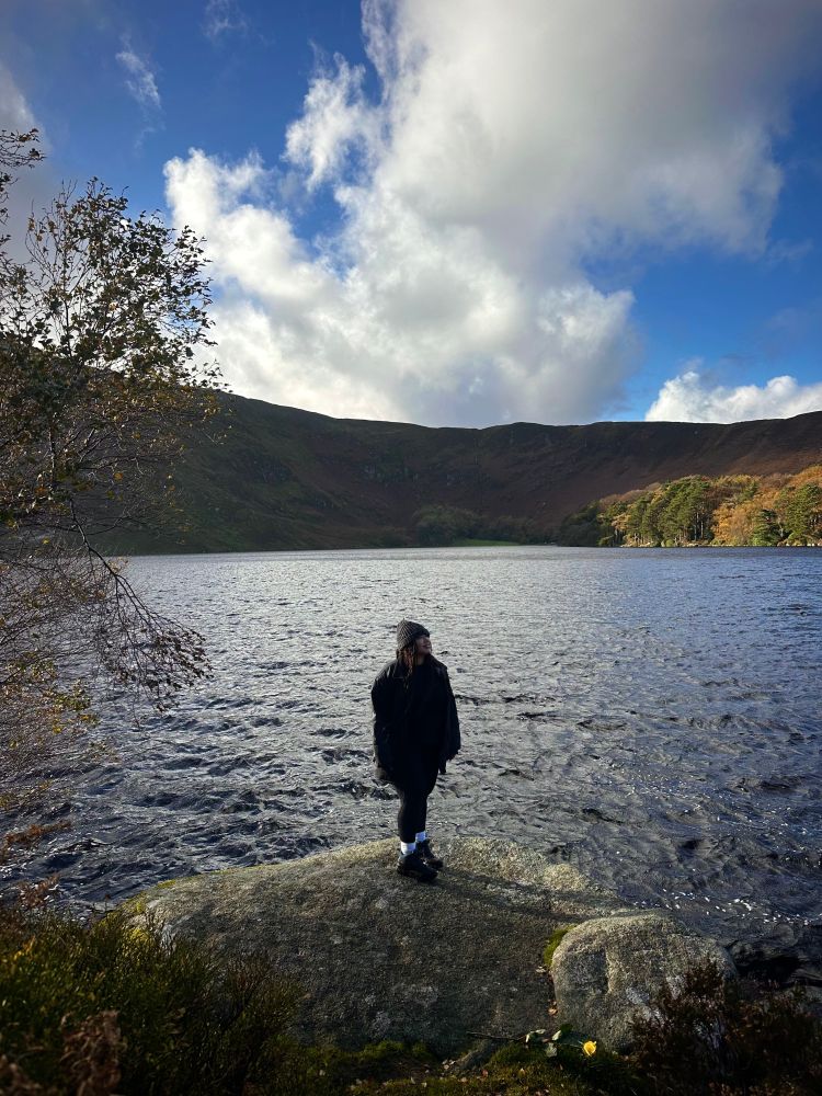 Me standing on a rock with a lake in the background 