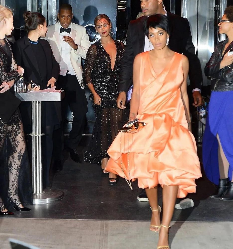 Solange Knowles walking away from Beyoncé and Jay z. They’re all in black tie attire 