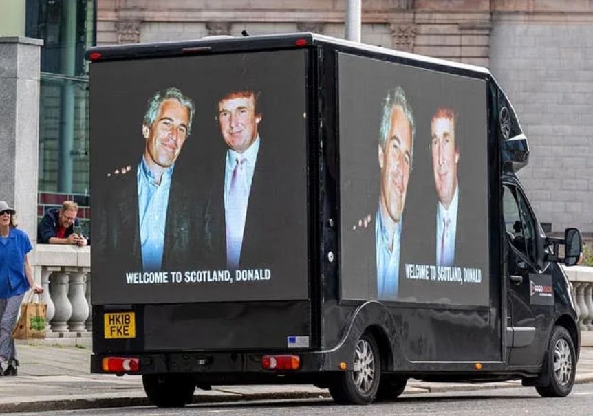 A lorry with picture of Epstein and trump with his arm around Epstein the bottom it says welcome to Scotland Donald 