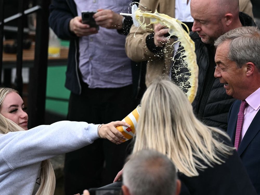 A woman throwing a milkshake at Nigel farage 