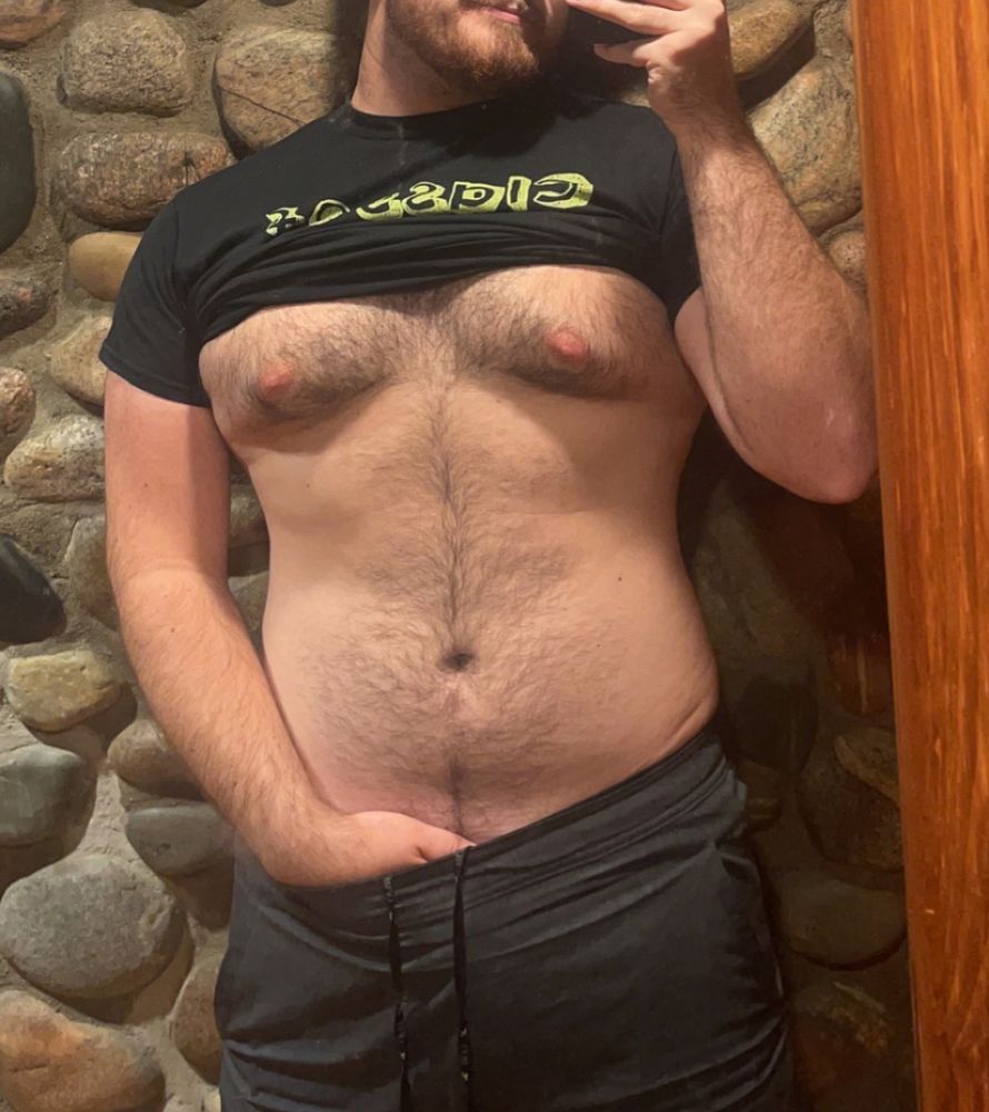 Mirror selfie of my with my shirt hiked up over my tits and my hand in my pants in front of a stone chimney. My tits look amazing.