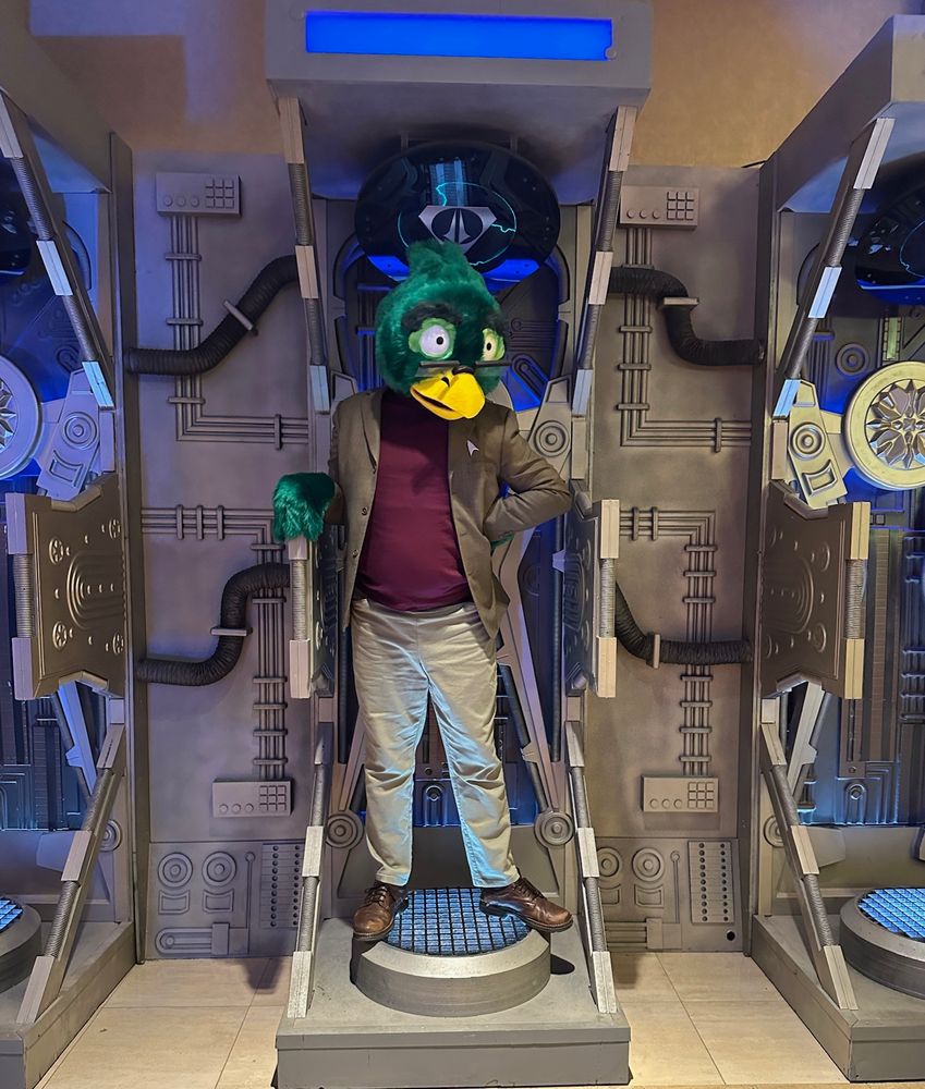 A photo of me as Dr Migleemo standing and posing with one hand on my hip in a recreation of a Borg regeneration chamber that is set up near the photoshoot area at STLV.
