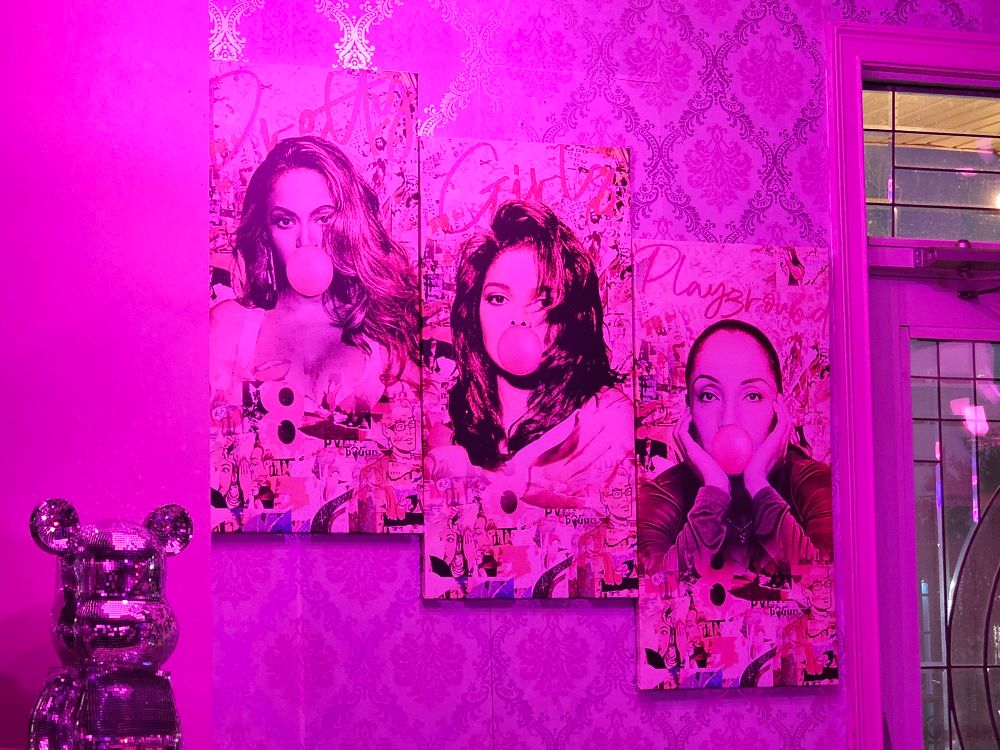 Beyonce, Janet and Sade blowing bubblegum in a mural on the wall of a restaurant.