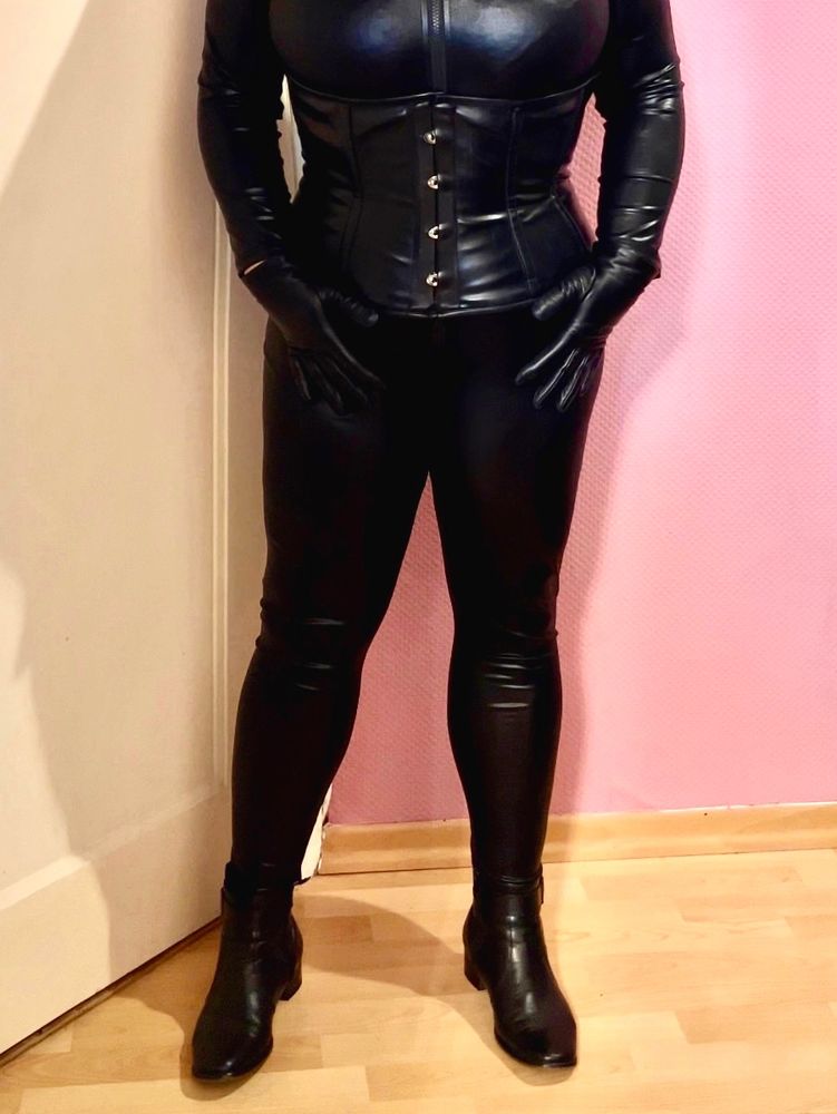 Ich stehe vor einen hellen Wand und trage enganliegende Kleidung.