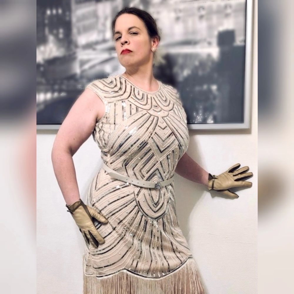 Ich trage ein cremefarbenes Vintage-Kleid im Stil der 20er Jahre und dazu farblich passende Lederhandschuhe. 