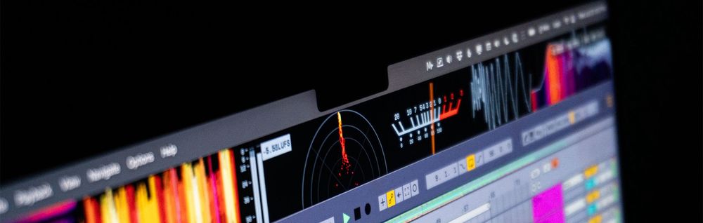 A photo of a MacBook Pro running MiniMeters v1.0 highlighting the new VU Meter.