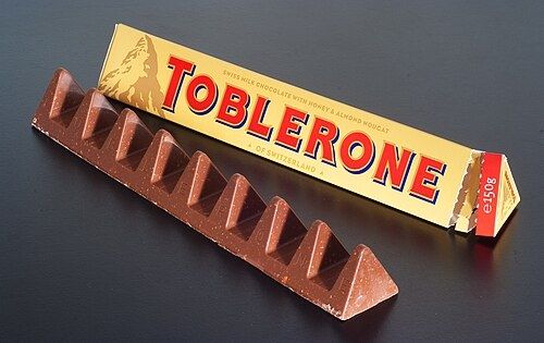 Imagem de uma barra e uma embalagem de Toblerone.