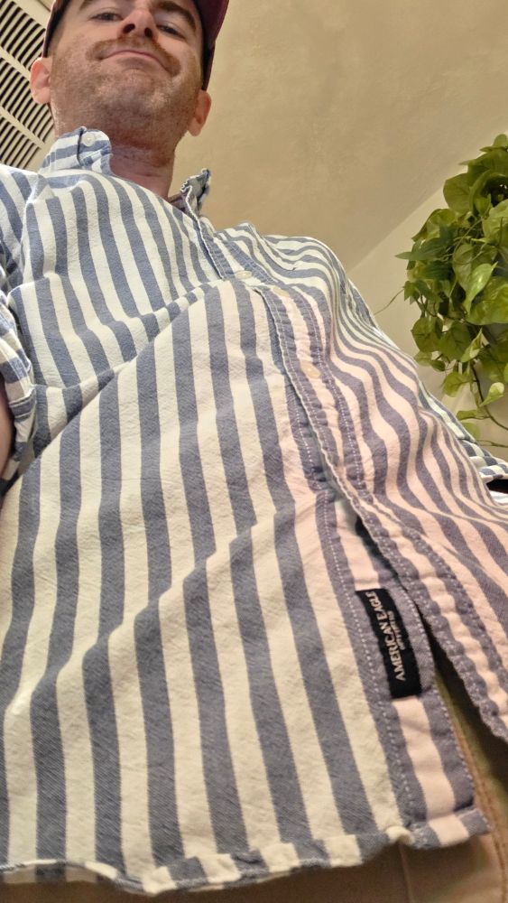 View from my crotch looking up my striped shirt to my smirking face 