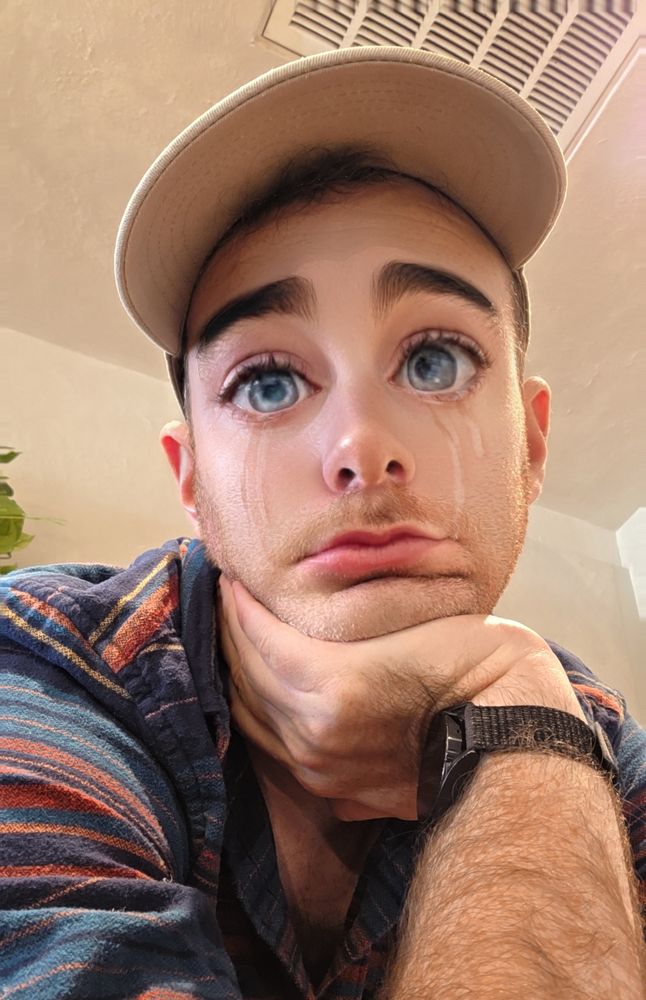 Selfie of me with a silly cartoon crying filter, resting my head on my hand