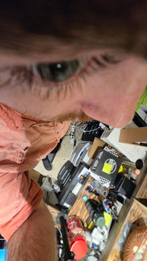 Fisheye shot from right above my eyebrow. Close up of one of my eyes pointing down my body showing a over crowded counter and mess cord set up on the floor