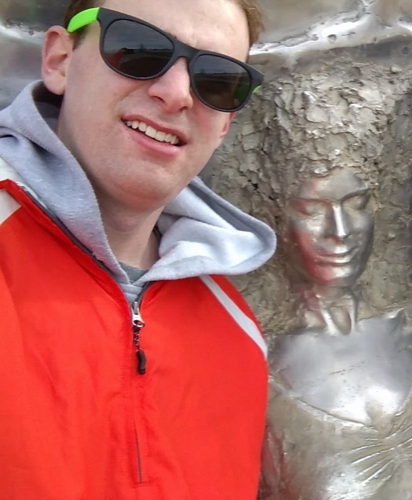 Baby Evan with a weird grimace/smile thing, cheap sunglasses next to a metal lady