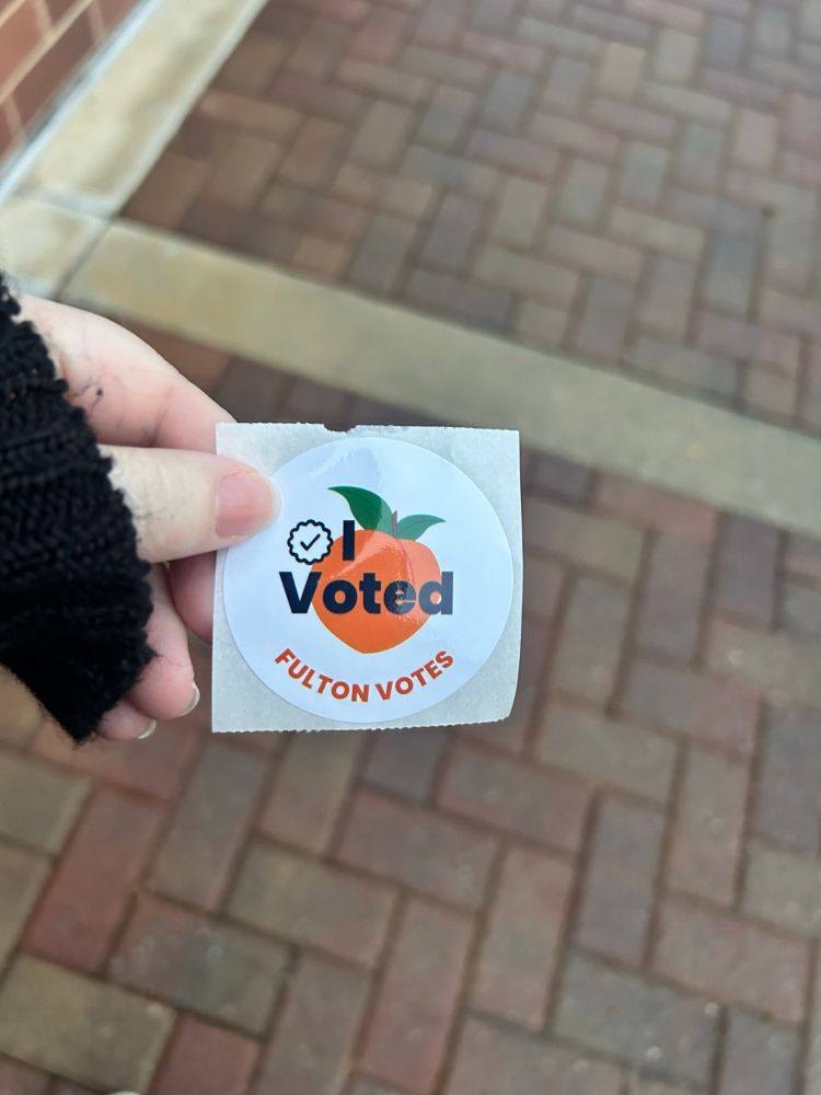 A picture of Judy holding a I voted sticker