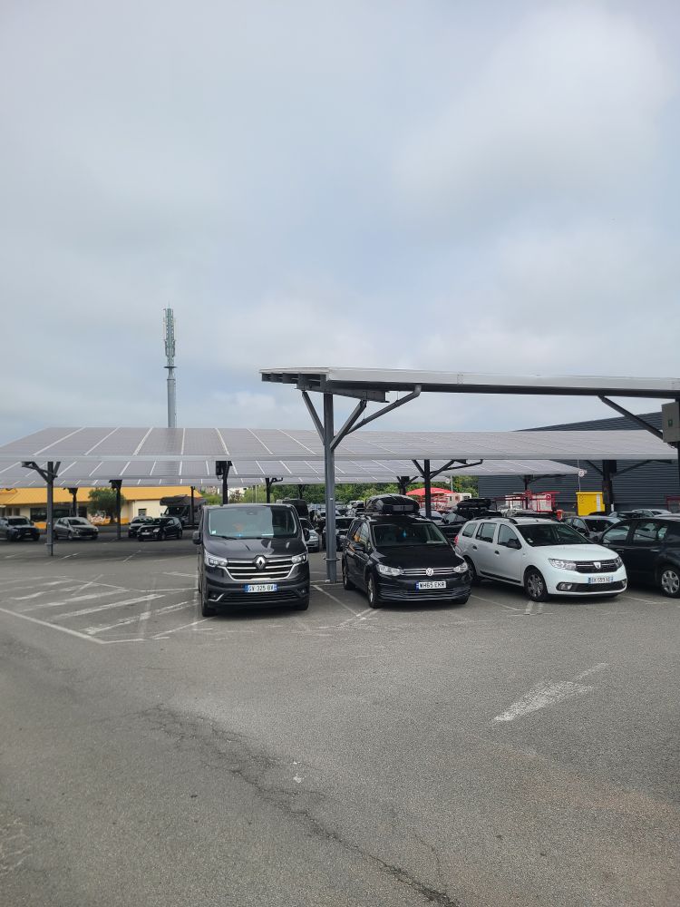 Three cars parked under a pv canopy.