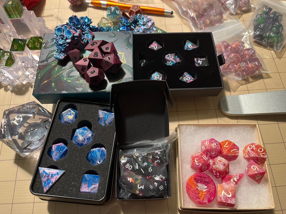 Six sets of gaming dice is various packaging.