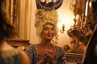 Ashley Park in a towering blond Regency-era wig (not quite as elaborate as a Queen Charlotte masterpiece, but plenty of height and curls). She’s dressed for a ball in a dress and jewels, gripping a glass, and looking mischievous—almost like she’s plotting how to knock out her final-round Rom Com Bracket competitor.
