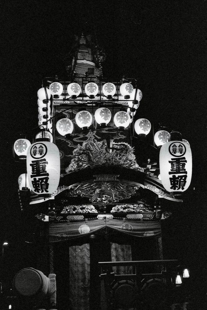 A Japanese float (dashi) at Kawagoe Festival in Saitama Prefecture. It is at night with it all light up. 
Shot in black and white film. 
