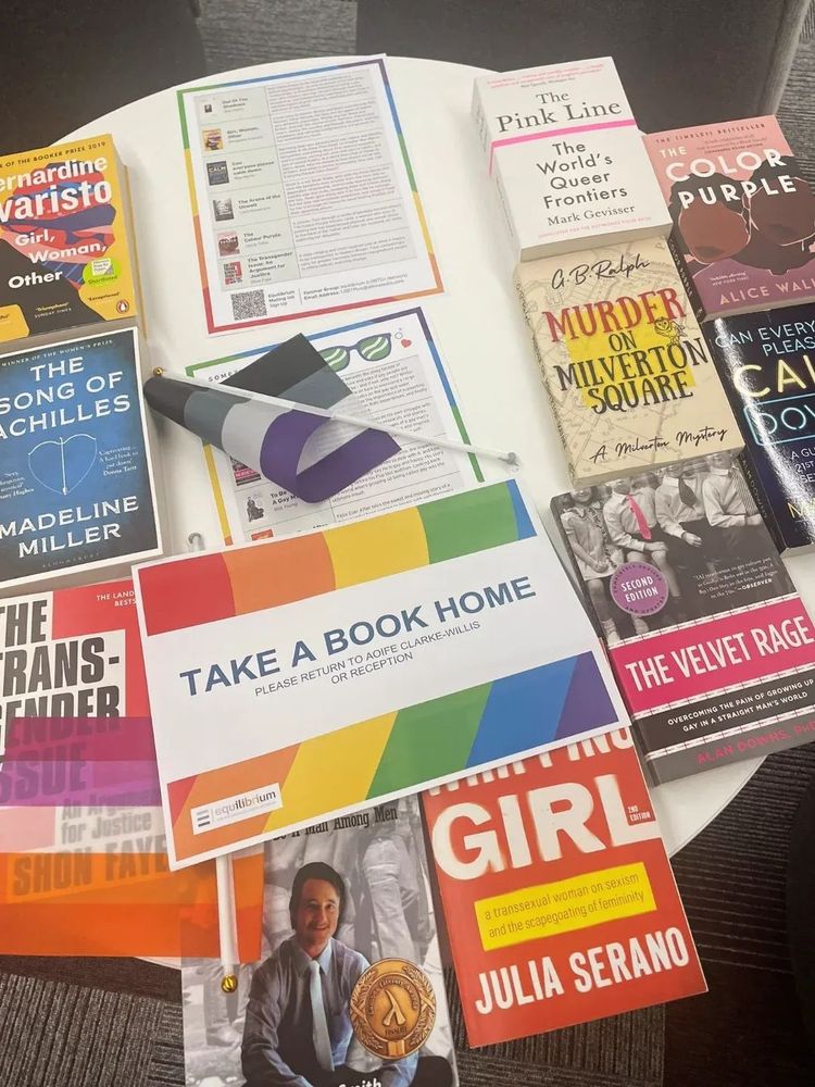 Table with queer books and a sign saying "Take a book home"