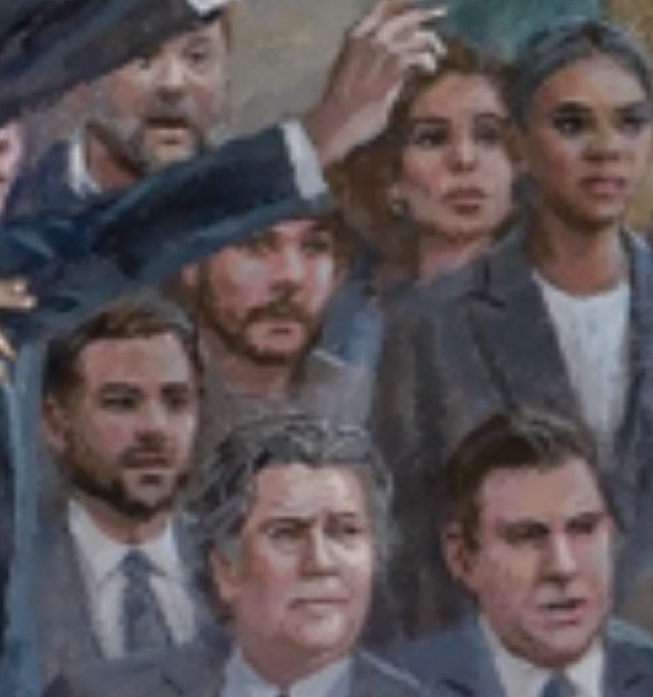 Tim Pool with just a sliver of his beanie showing, mostly covered by someone’s arm to hide the shame. 