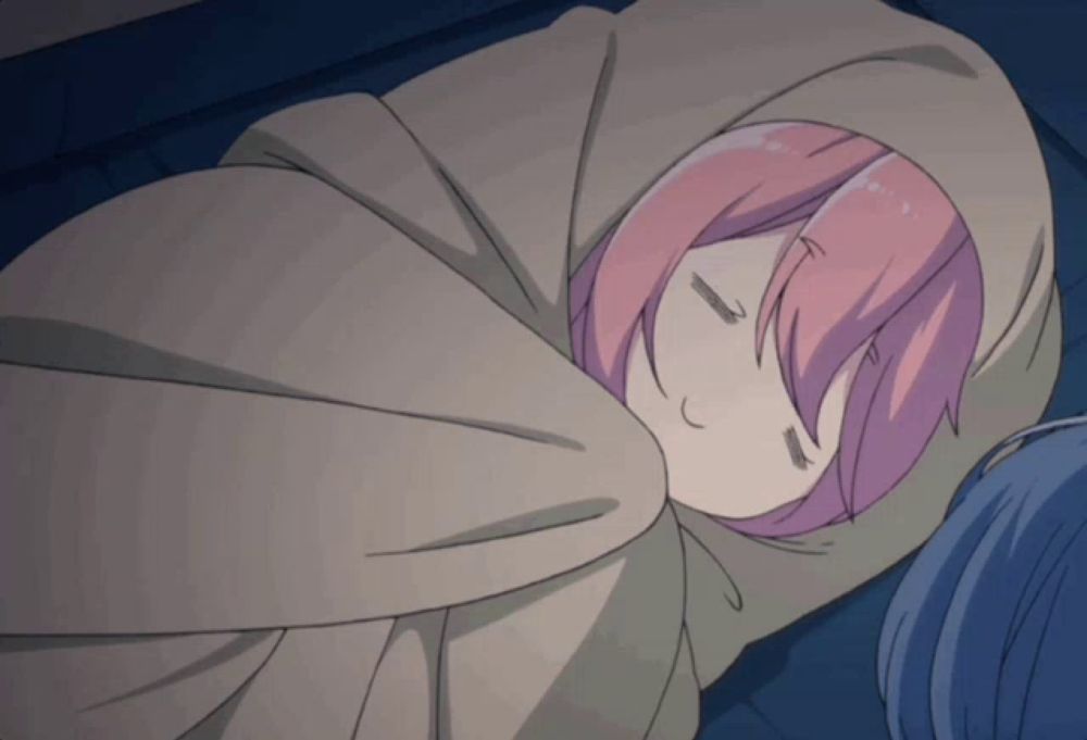 a girl with pink hair sleeping in a blanket