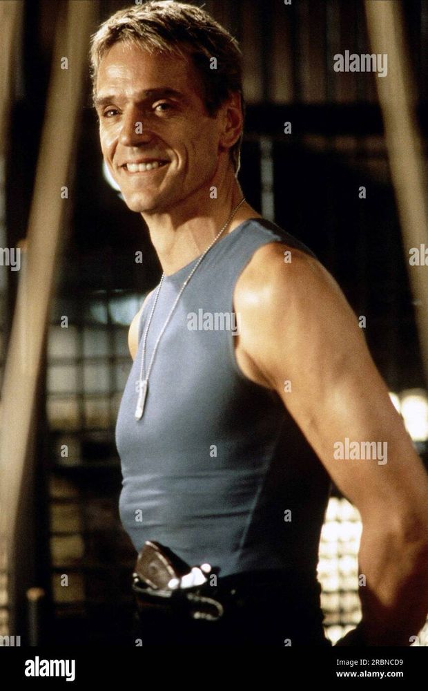 Jeremy irons as Simon in die hard with a vengeance, smiling and looking into the camera 
