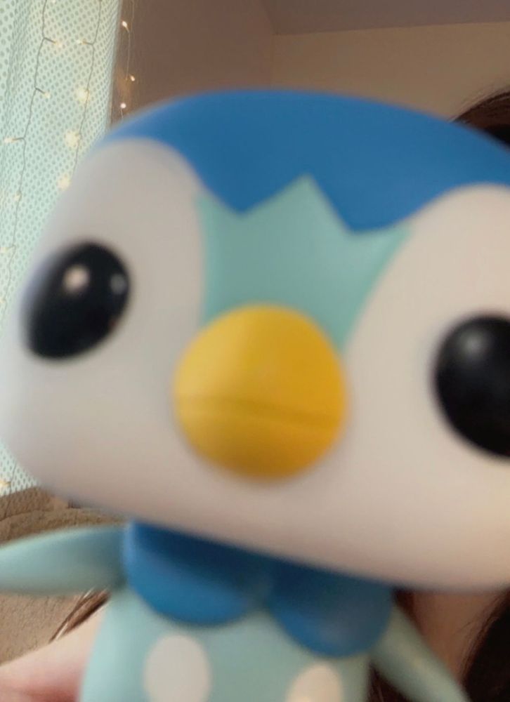 A piplup pop figure that is very blurry and close up to the screen