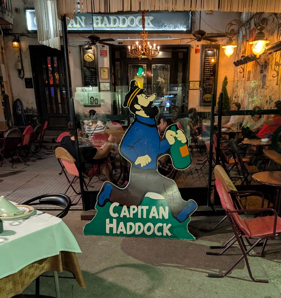 Standee of Captain Haddock holding a bottle of whiskey while running, outside of Capitan Haddock bar.