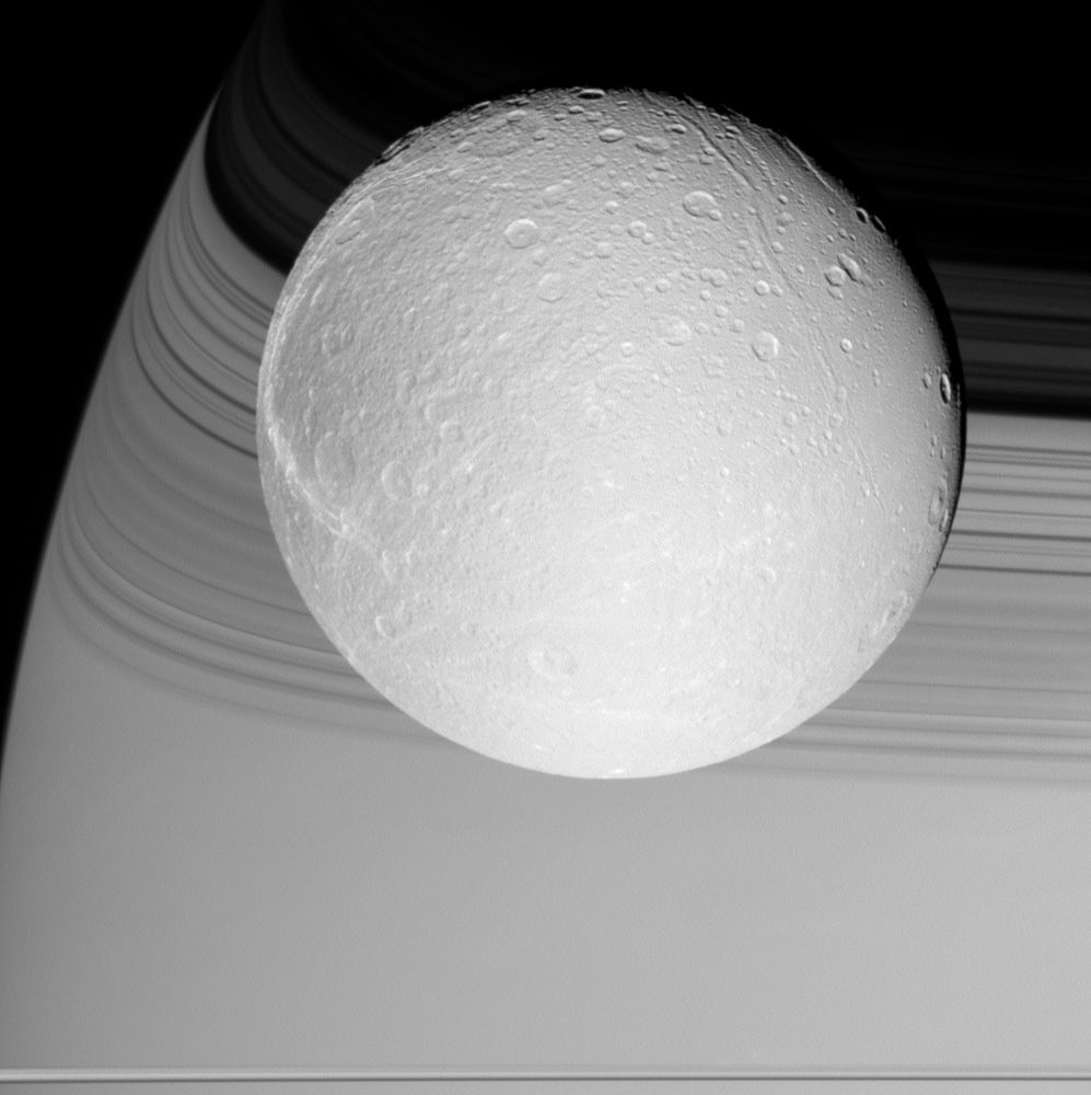 A nearly fully illuminated Dione with a limb of Saturn in the background. Because the rings are made up of many smaller ringlets, the shadows on Saturn appear as dark and light bands.

NASA/JPL-Caltech/SSI/CICLOPS/Kevin M. Gill