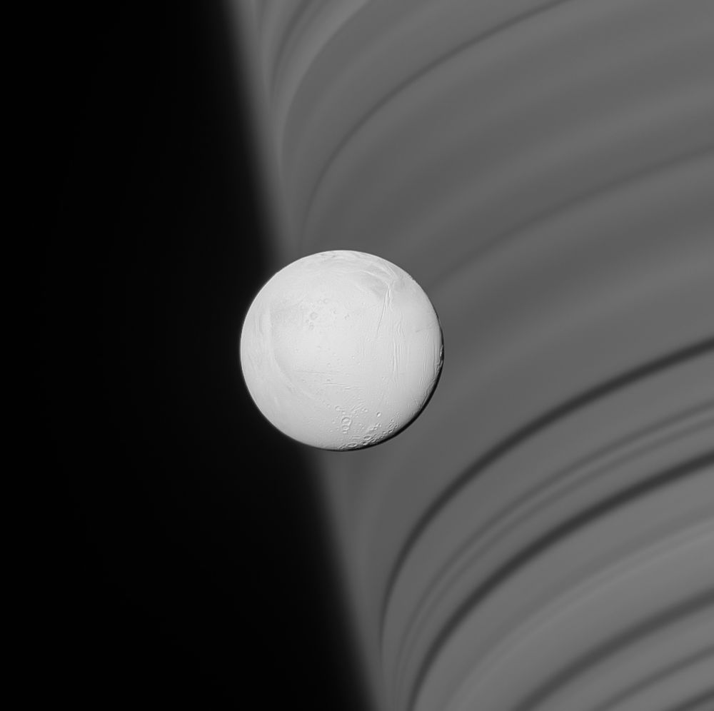 A nearly fully illuminated Enceladus with a limb of Saturn in the background. Because the rings are made up of many smaller ringlets, the shadows on Saturn appear as dark and light bands.

NASA/JPL-Caltech/SSI/CICLOPS/Kevin M. Gill