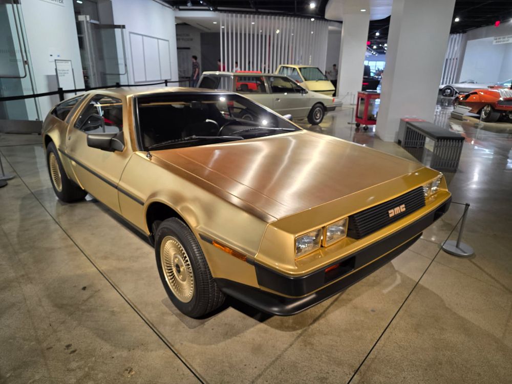 A low profile classic car covered in gold metal.