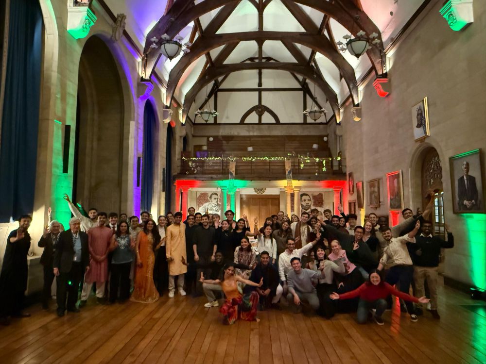 A group photo of Scholars in a colourfully lit hall