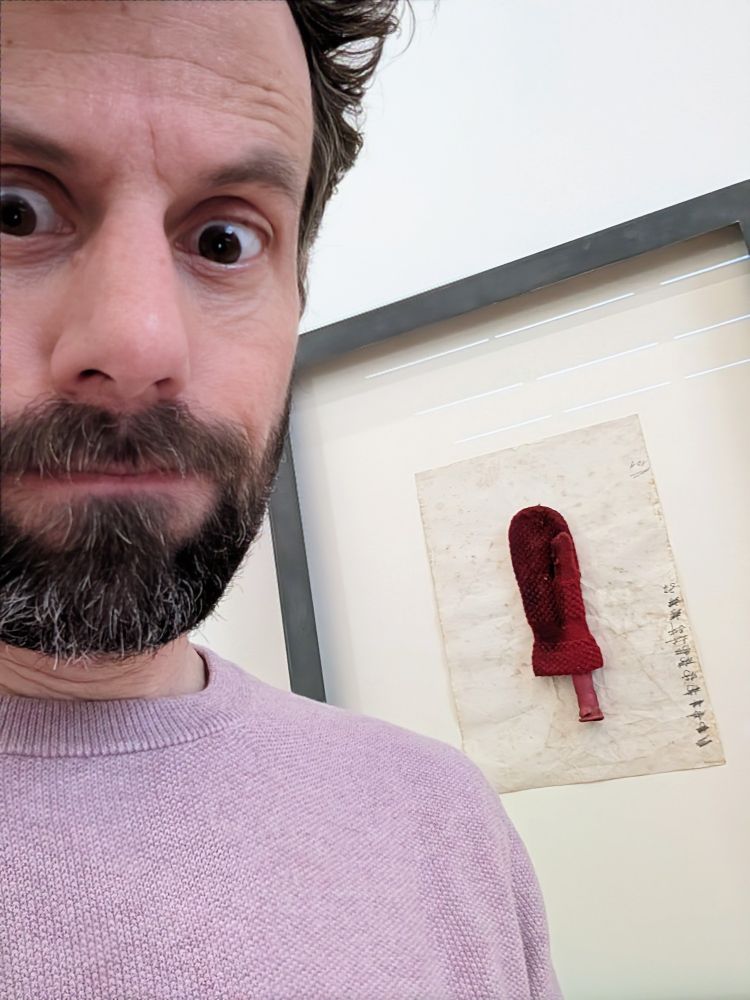 Selfie von mir. Im Hintergrund ein Werk von Joseph Beuys, das im Wesentlichen aus einem Kinderhandschuh besteht.