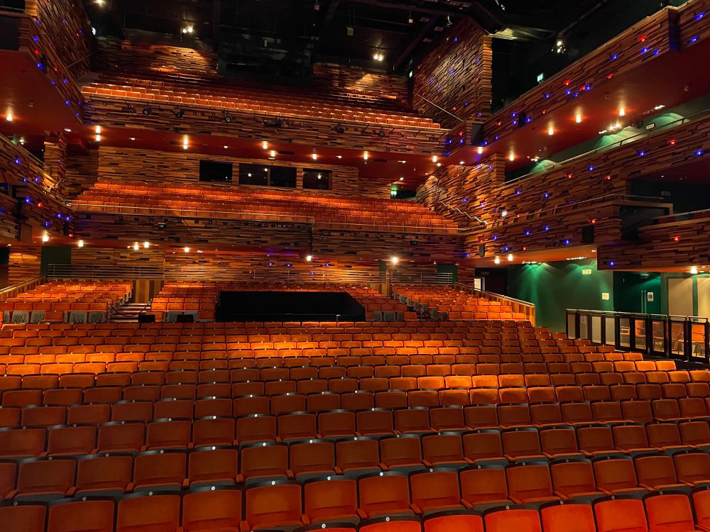 An empty theatre auditorium with all the house lights on