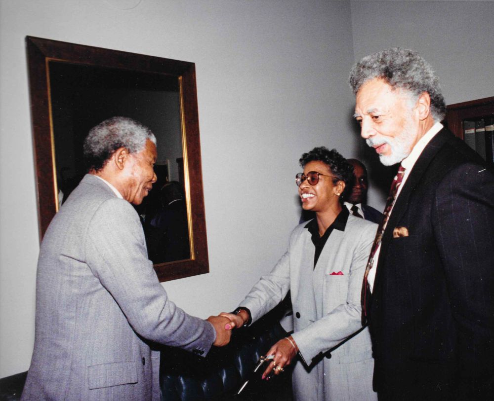 Carlottia Scott shakes Nelson Mandela's hand while standing next to Rep Ron Dellums