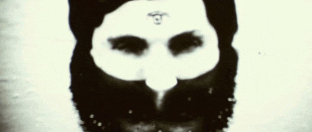 a black and white photo of a person 's face with a symbol on it