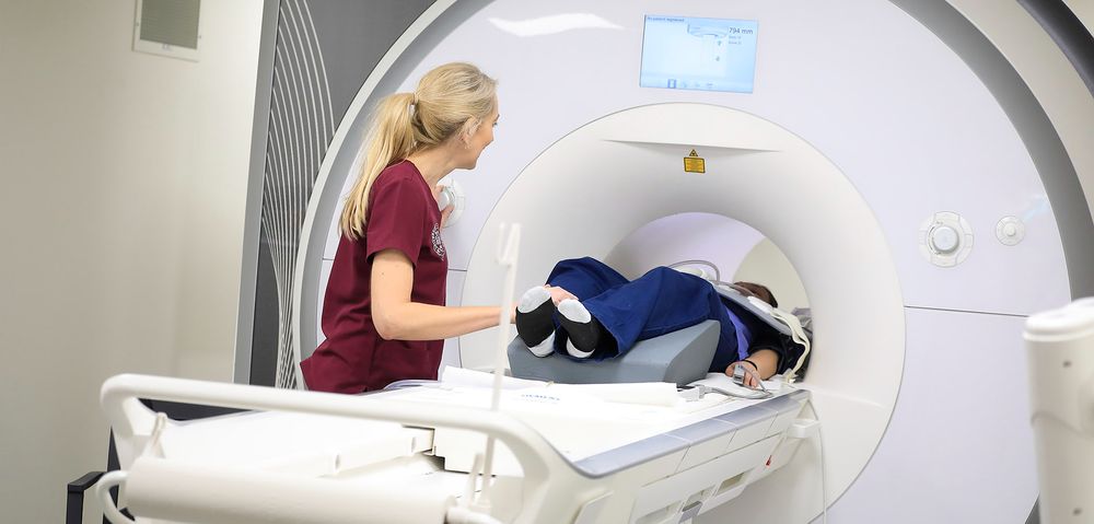 A technician oversees a patient in an MRI machine