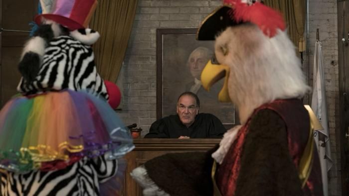 Screen capture from The Good Fight season 5 (aired in 2021), where people appear in silly costumes in front of « judge » Wackner’s private court. 