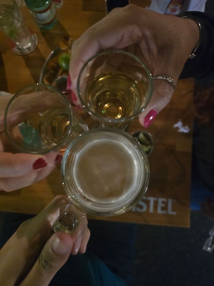 Foto de dois copos de cachaça e um de cerveja em um brinde