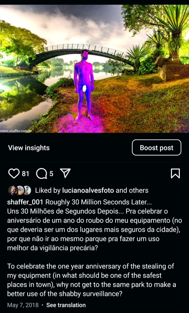 Foto noturna de um homem nu junto da ponte de ferro do parque do Ibirapuera, em São Paulo. O homem está sendo colorido por um facho de luz rocha em meio ao verde e marrom da vegetação.