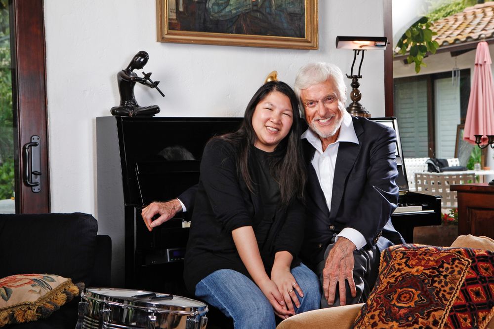 Cynthia Wang (left) and Dick Van Dyke, sitting in front of his piano in his living room.
