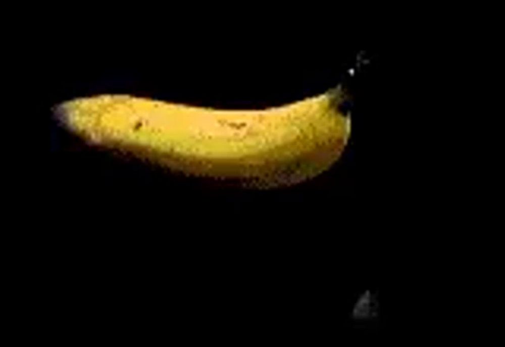 a close up of a piece of food being cut with a knife on a black background .