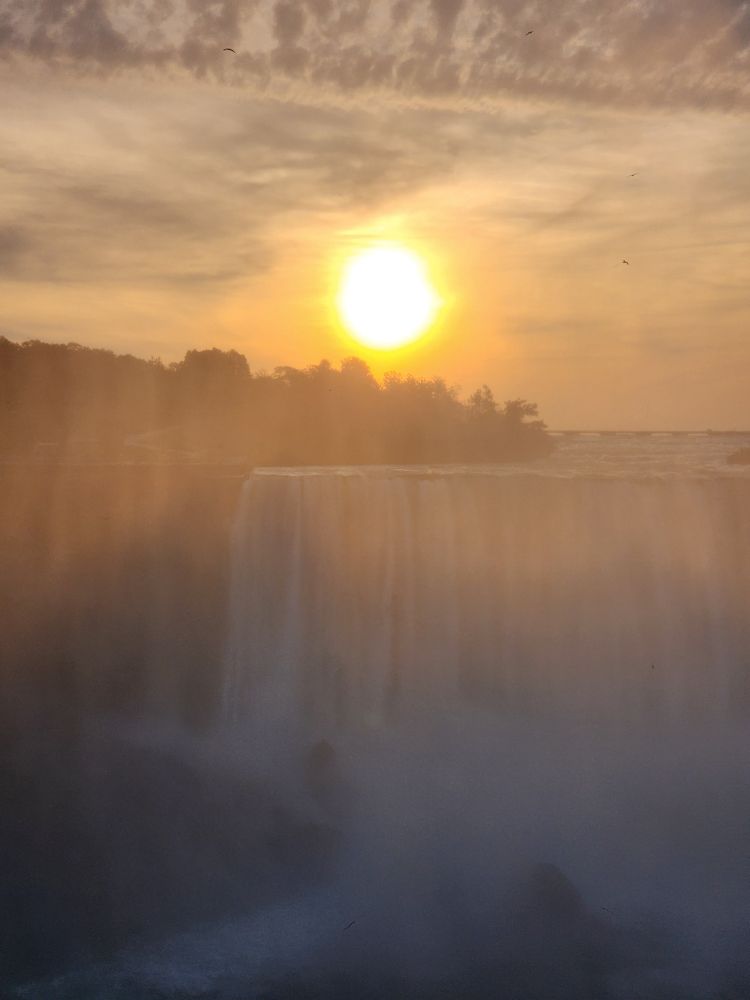 The sun is seen rising through the mist over the Horseshoe Falls at Niagara Falls 