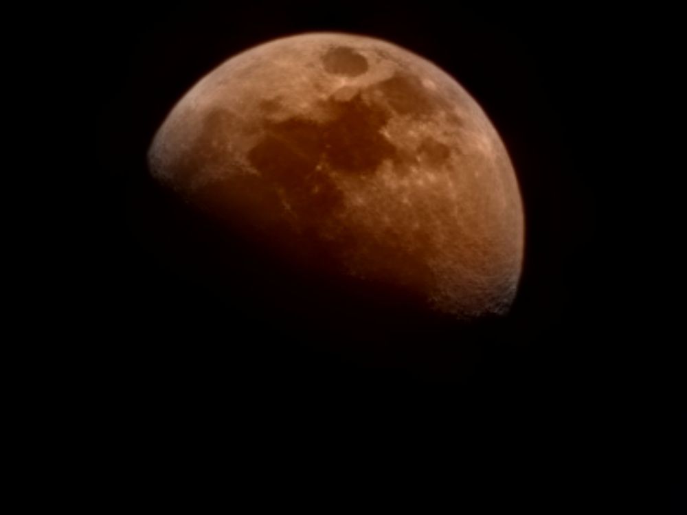 A reddish moon, probably enhanced by Samsung AI despite using a 100x "Space Zoom" gimmicky lens, as seen over Port Colborne Ontario on August 2 2025.