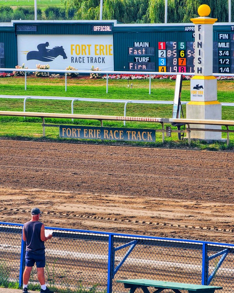 A Punter sits by the fence, waiting for the next race at Fort Erie Race Track in Fort Erie Ontario 