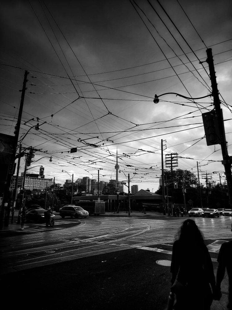 The CN Tower is seen in the distance from Bathurst and Dundas Streets as a thunderstorm forms in Toronto in July 2025