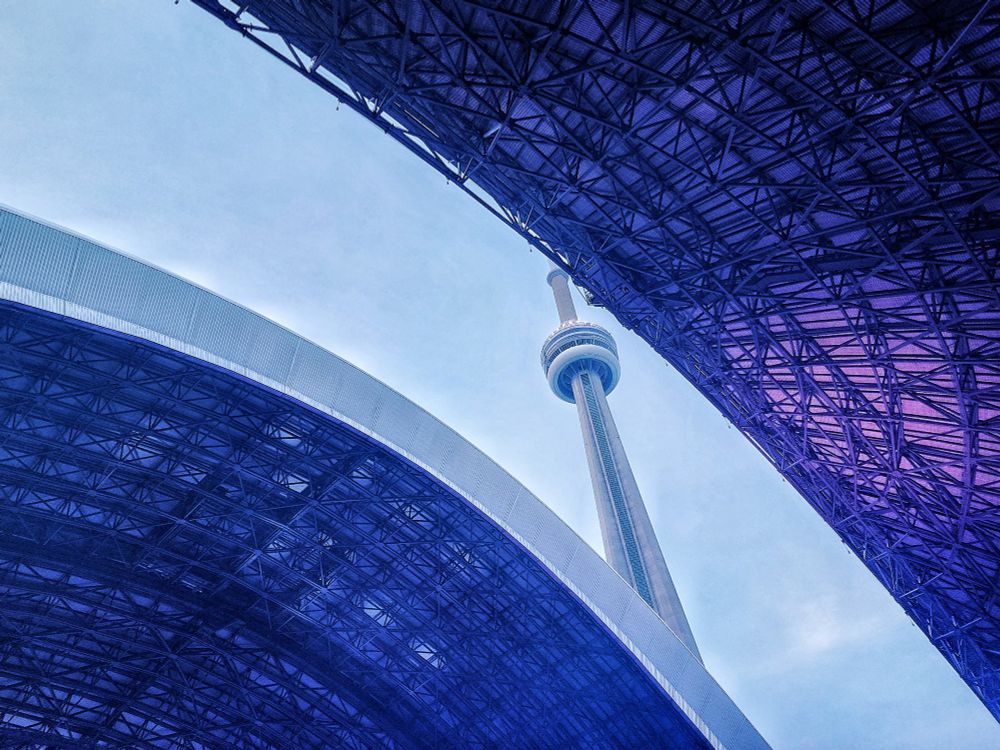 The CN Tower is seen through the opening roof of Rogers Centre in Toronto Ontario 