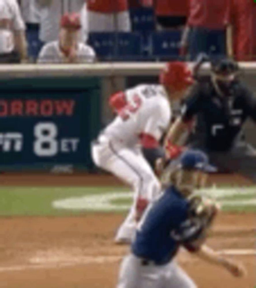 a baseball game is being played on a field with a sign that says arrow on it .