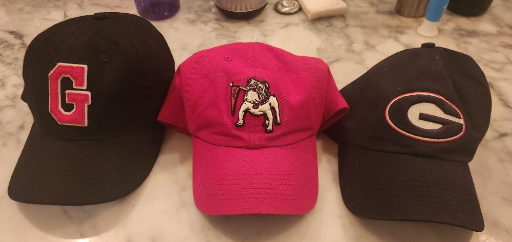 Three University of Georgia Bulldogs hats.  

1) Black flannel with a vintage red G.


2) Red wool blend with vintage Uga biting a pennant.


3) Black wool blend with a black Super G.