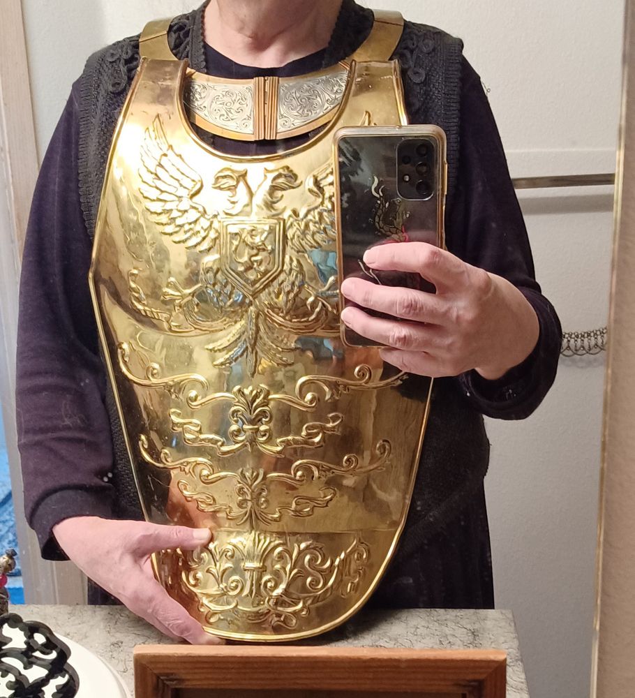 Roman style embossed brass breastplate, held up to my body and photographed in a mirror.  The gorget was already in my jewelry collection.