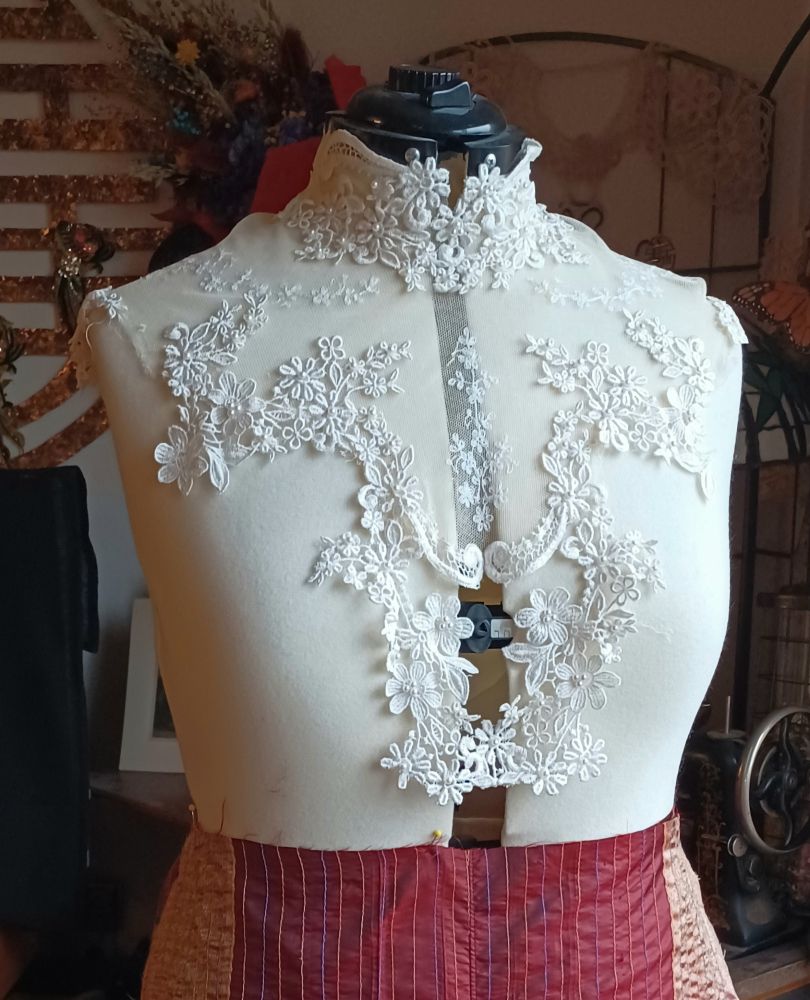 The lace has been stripped from the bodice of the wedding gown.  The lace was glued in several places so I am hand sewing it onto the netting.  Fake pearls were also glued to the lace, which I removed by dabbing with rubbing alcohol.  The bodice opened up the back, so the back is now the front, and this view will cover the back of my new piece - probably a jacket.