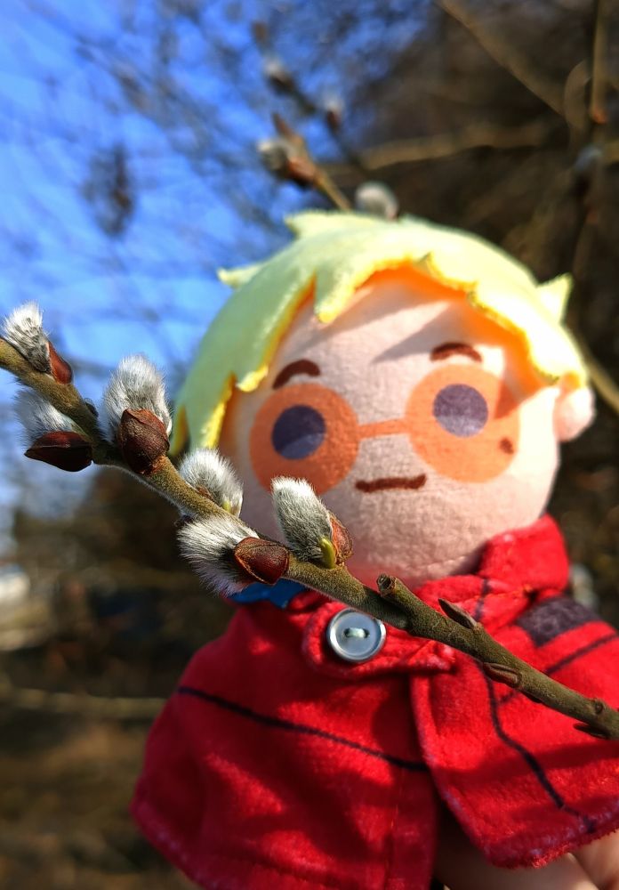 Closeup photo of a TeruVa plushie with a little branch of catkins.